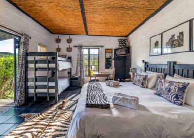 Zebra Chalet 1 Zebra chalet's bedroom equipped with a king-sized bed and two bunk beds