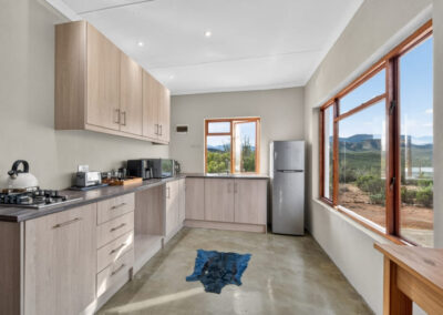 Kudu chalet's kitchen equipped with a stove, microwave, refrigerator and sink.