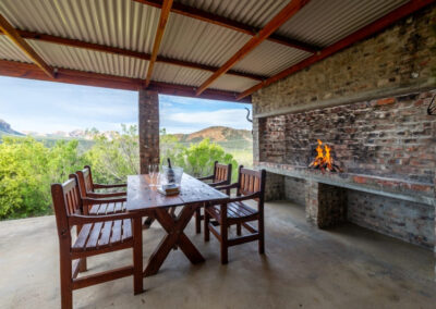 Kudu chalet's private veranda equipped with a outdoor fireplace and dining table